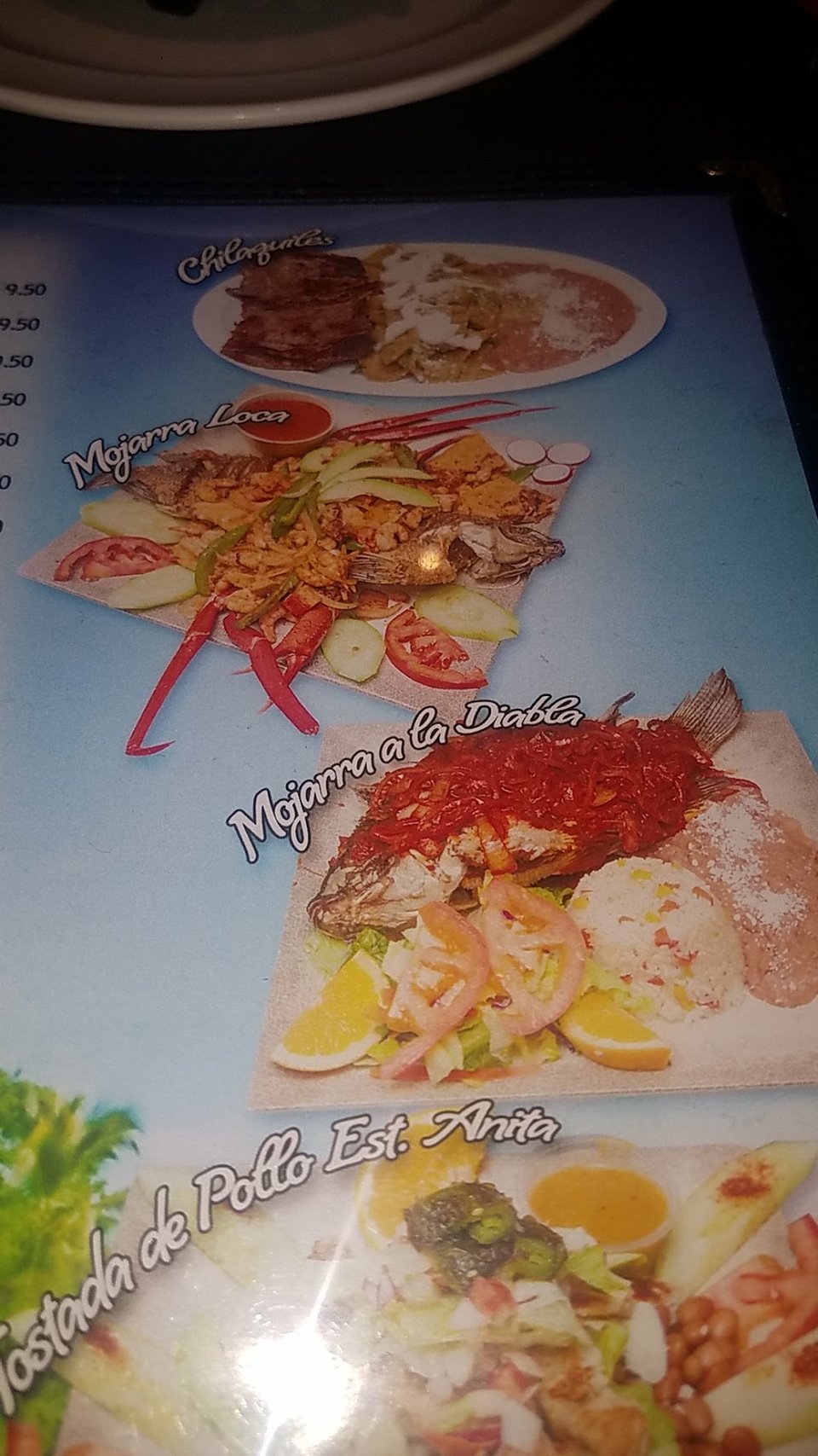 Printed menu with tacos and seafood sections.